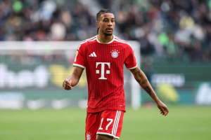 Soccer player in a red Bayern Munich jersey with number 17 on the green field during a match.