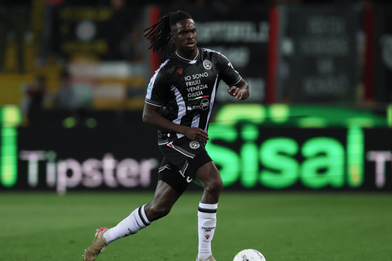 hupu-football-1780830105802-kaiyun-1png - 开云体育中心 Soccer player in black-and-white kit running with the ball on a pitch, stadium lights in the background.