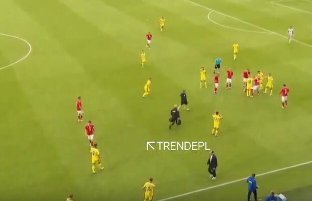 hupu-football-1780876300811-kaiyun-0jpg - 开云体育中心 Soccer match on a green field with red and yellow team players; officials and substitutes near the center, with a white on-screen text label 'TRENDEPL'