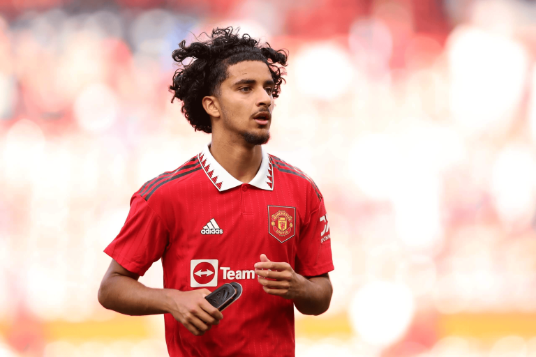 hupu-football-1780914419036-kaiyun-1png - 开云体育中心 Manchester United player in a red jersey running on the field, holding shin pads.
