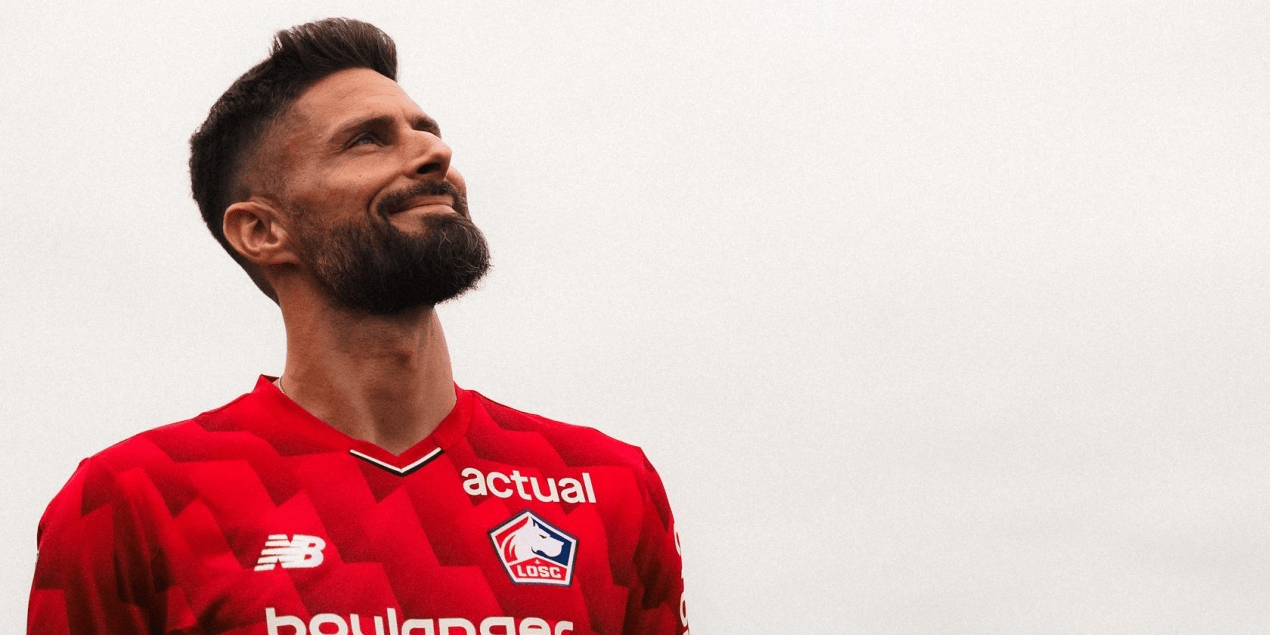 hupu-football-1780949219224-kaiyun-0png - 开云体育中心 Man with a beard in a red soccer jersey looking upward against a pale sky.