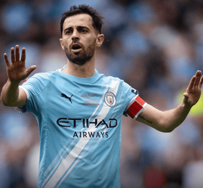 hupu-football-1780985128347-kaiyun-1png - 开云体育中心 Manchester City footballer wearing a sky-blue kit with Etihad Airways sponsor raises both hands on the field, captain's armband visible on his left arm
