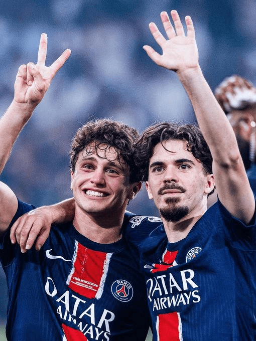 hupu-football-1781077357228-kaiyun-0png - 开云体育中心 Two Paris Saint-Germain teammates celebrate, arms around each other, one flashing a peace sign in blue PSG kits.