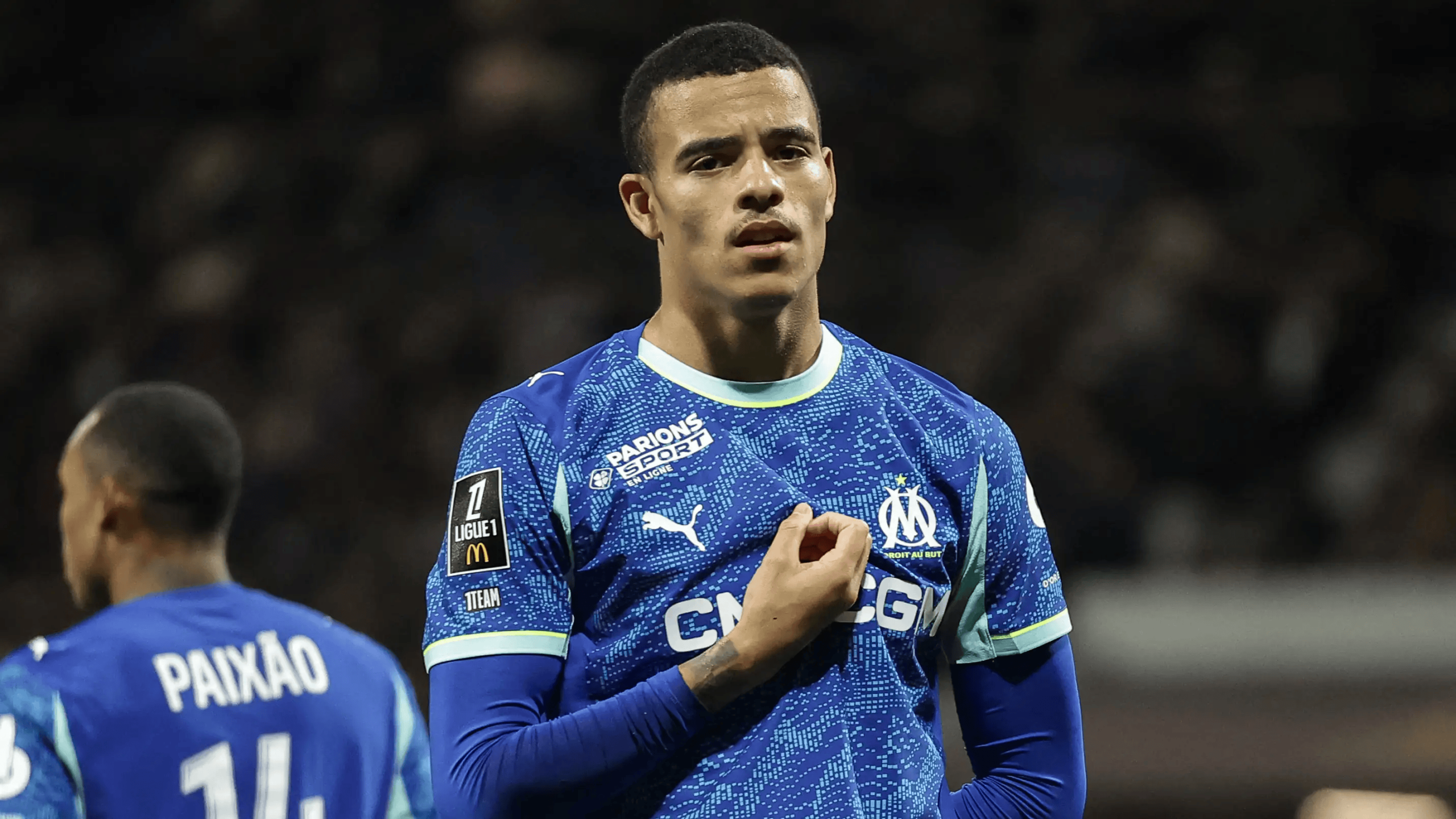 hupu-football-1781261081931-kaiyun-0png - 开云体育中心 Soccer player in blue Marseille jersey adjusting his shirt during a match, stadium lights in the background