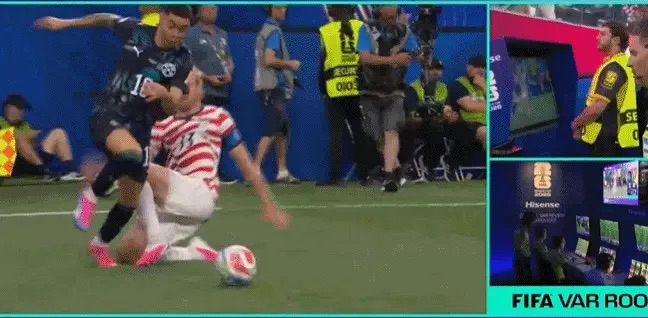 Soccer match action: a sliding tackle between a dark-kit player and a white-red striped opponent; inset panels show VAR room with officials and multiple monitors.